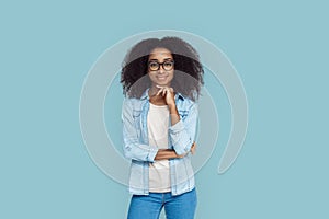 Freestyle. African girl wearing glasses standing isolated on gray touching chin smiling confident