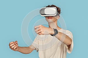 Freestyle. Man in vr headset standing isolated on gray playing game driving concentrated