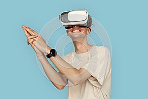 Freestyle. Man in vr headset standing isolated on gray playing shooting game cheerful