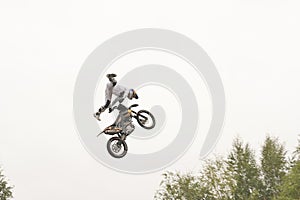 Freestyle motocross. Biker rider doing a jumpin the air. Perfoming acrobatic stunt flying. Fmx motocycles. protective