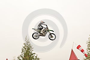 Freestyle motocross. Biker rider doing a jumpin the air. Perfoming acrobatic stunt flying. Fmx motocycles. protective