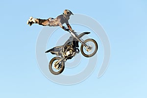 Freestyle motocross rider performs the trick in jump at fmx competitions photo