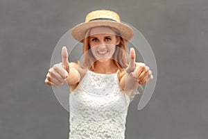 Freestyle. Young woman in hat standing  on wall showing thumbs up close-up joyful blurred