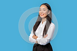 Freestyle. Young woman wearing shirt and skirt standing isolated on blue crossed arms posing confident