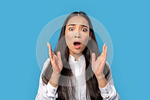 Freestyle. Young woman wearing shirt and skirt standing isolated on blue hands up screaming concerned