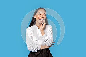 Freestyle. Young woman wearing shirt and skirt standing isolated on blue laughing happy