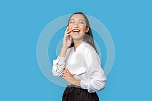 Freestyle. Young woman wearing shirt and skirt standing isolated on blue touching face laughing happy