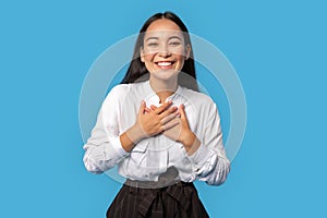 Freestyle. Young woman wearing shirt and skirt standing isolated on blue touching heart laughing cheerful