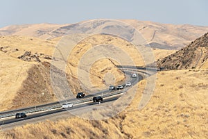 Freeway road crossing the the San Luis Reservoir valleys during dry and hot season, California, USA photo