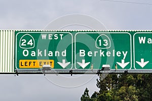 Freeway signage providing information about the lanes going to Oakland and Berkeley; San Francisco bay area, California