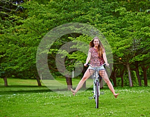 Freewheeling fun. Shot of a young woman cycling in the park.