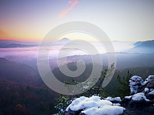 Freeze autumnal daybreak, rocks covered with fresh powder snow. Stony rock