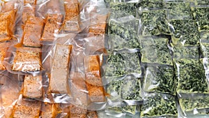 Freeze cooked salmon and cheesy creamed spinach in vacuum plastic packs, concept of food preservation