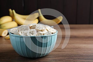Freeze dried and fresh bananas on wooden table. Space for text