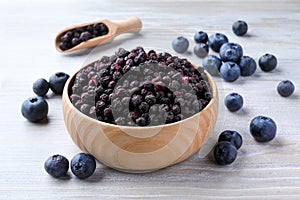 Freeze dried and fresh blueberries on white wooden table