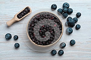 Freeze dried and fresh blueberries on white wooden table, flat lay
