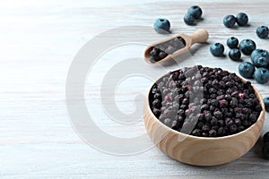 Freeze dried and fresh blueberries on white wooden table. Space for text