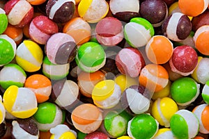 Freeze dried Skittles hard candy colorful macro with splits through their centers. photo