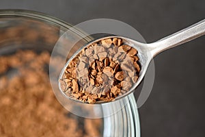 Freeze Dried Instant Coffee on Tea Spoon with Glass Coffee Cup Background