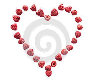 Freeze dried raspberries on a white background in the form of heart. Lyophilization. Food for astronauts.