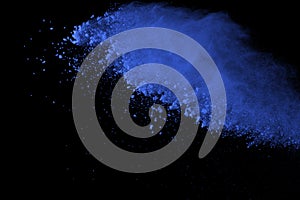 Freeze motion of blue powder explosions isolated on black background.