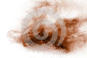 Freeze motion of brown dust explosion. Stopping the movement of brown powder. Explosive brown powder on white background