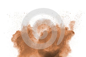 Freeze motion of brown dust explosion. Stopping the movement of brown powder. Explosive brown powder on white background