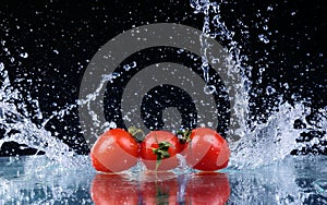 freeze motion of cherry tomatoes in water splash on black background