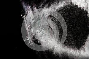 Freeze motion explosion of white dust on a black background.