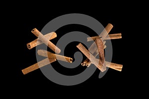 Freeze motion of flying group of Cinnamon Sticks . Isolated on black background.