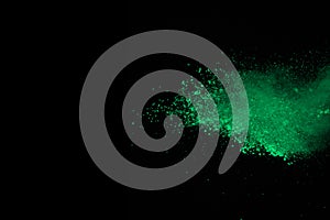 Freeze motion of green powder explosion on black background. Stop motion of green dust on dark background. Explosive green cloud