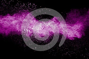 Freeze motion of purple dust splattered on dark background.