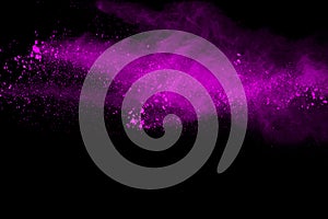 Freeze motion of purple powder exploding on black background.