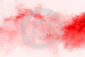 Freeze motion of red powder exploding, on white background.