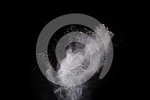 Freeze motion of white color powder exploding on black background.