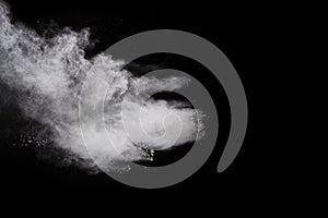 Freeze motion of white color powder exploding on black background.