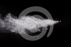 Freeze motion of white color powder exploding on black background.