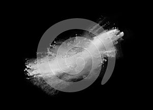 Freeze motion of white dust explosion on black background. Stopping the movement of white powder on dark background