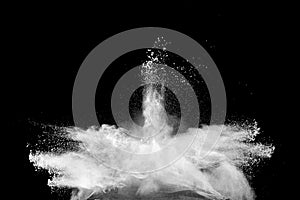 Freeze motion of white dust particles splash on black background.White powder explosion clouds