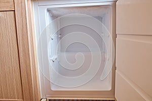 Freezer with ice on the walls in the built-in refrigerator. Close-up