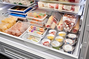 freezer with variety of frozen foods and snacks, including individually wrapped ice pops