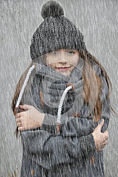 Freezing girl with bobble hat standing in the rain