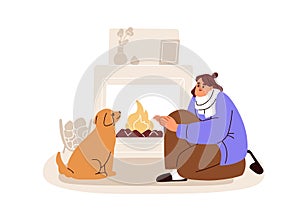 Freezing at home. Frozen woman warming at fire, cozy fireplace. Person and dog pet, cute puppy at fireside in apartment