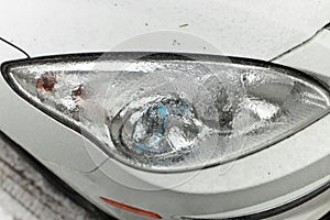 Freezing Rain Creates a Layer of Ice and Coats a Passenger Vehicle. Close up of Headlights