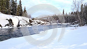 Freezing river flowing under bridge