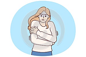 Freezing woman hugging shoulders trying to keep warm and feeling chills after contracting flu