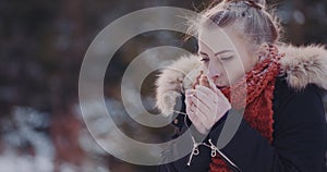 Freezing woman warming up hands in winter