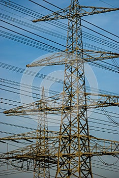 Freight crossing mast for high voltage with many lines against blue sky with veil clouds photo