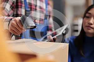 Freight distribution center employee using barcode scanner in warehouse