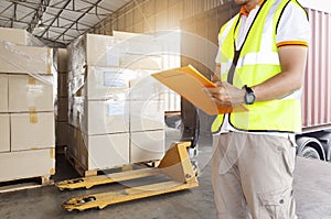 Freight industry warehouse shipment transport. Worker courier holding clipboard checking on checklist load cargo into a truck.